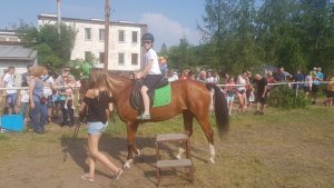 dziecko siedzi na koniu, prowadzi go kobieta trzymając konia