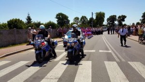 dwóch policjantów na motocyklach służbowych a za nimi ustawione osoby w rzędach