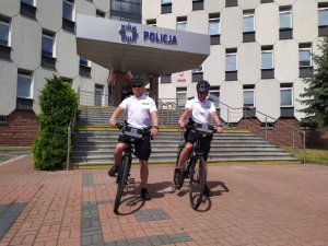 dwóch policjantów na rowerach w mundurach pozują do zdjęcia przed Komendą Miejską w Częstochowie