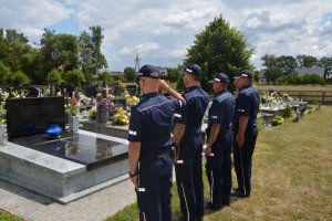 4 policjantów oddaje honor przed grobem