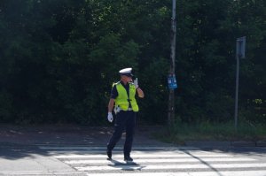 policjant na przejściu kieruje ruchem