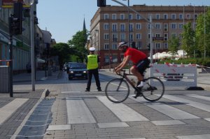 rowerzysta w ruchu w tle policjant w kamizelce kieruje ruchem