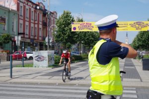 policjant kieruje ruchem w tle rowerzysta
