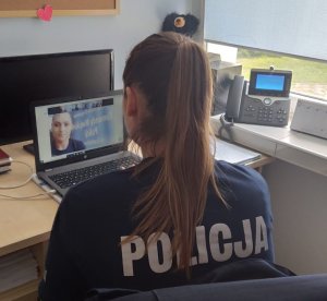 Policjantka siedząca przed laptopem prowadzi lekcje online
