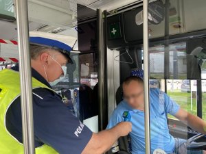 policjant bada stan trzeźwości kierowcy autobusu