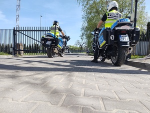 Policyjny patrol na motocyklach wyjeżdża z bramy na drogę