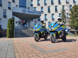 Policjanci na motocyklach parkują przed budynkiem komendy